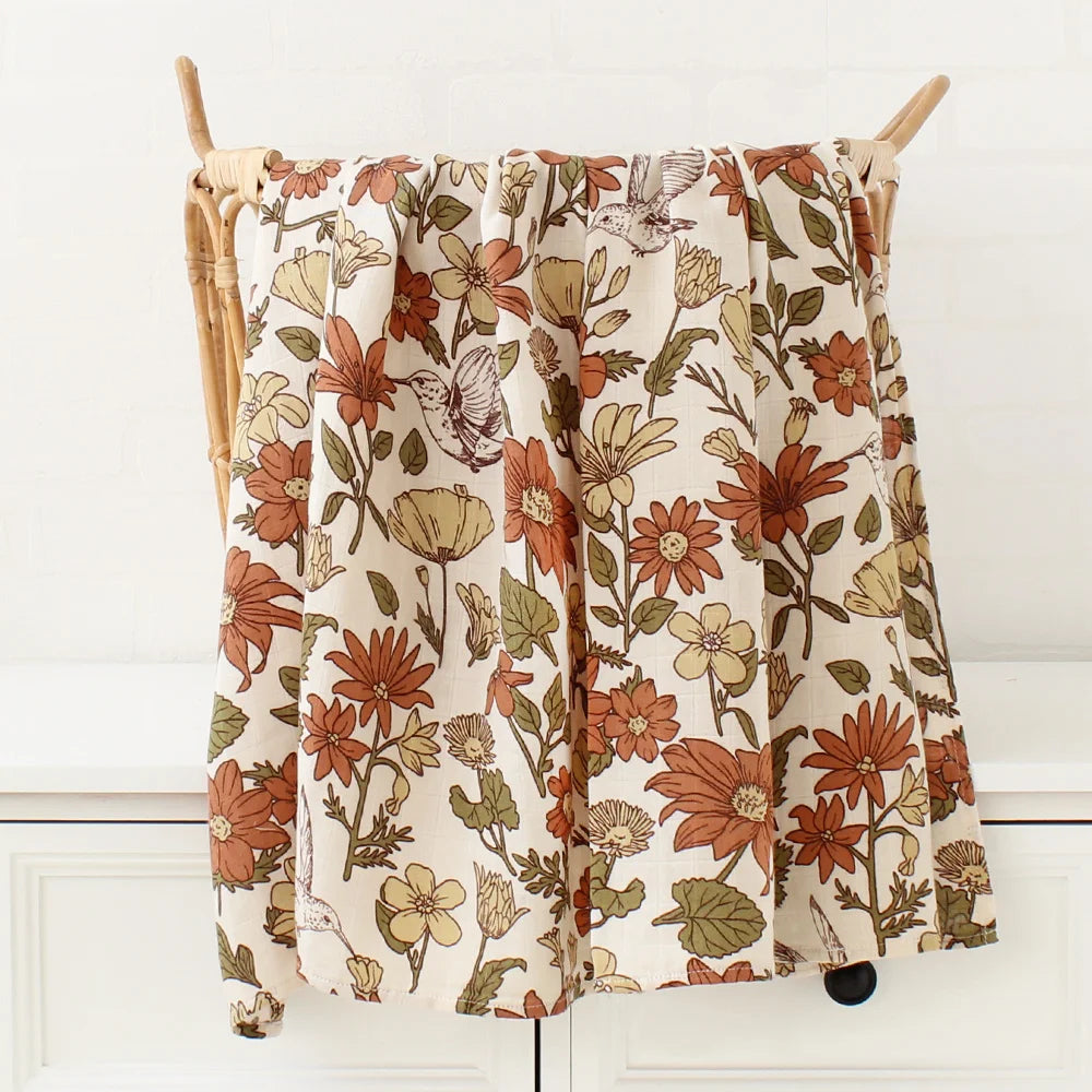 Jupe Couverture Bébé en Coton et Bambou Bio imprimé fleuri accrochée sur un cintre en bois sur fond blanc par BABY PREMA.