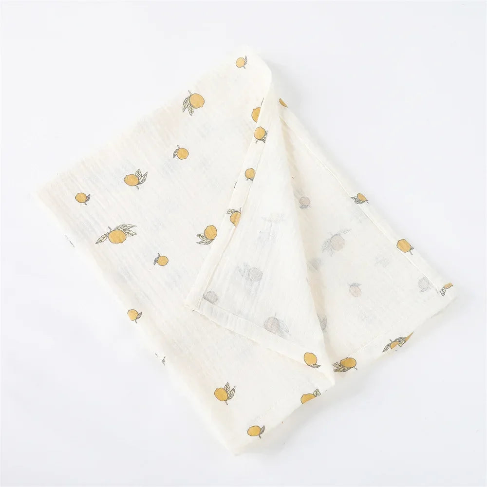 Serviettes pliées en coton au délicat imprimé citron sur fond blanc, parfaites en BABY PREMA Couverture Emmaillotage en coton pour Bébé.