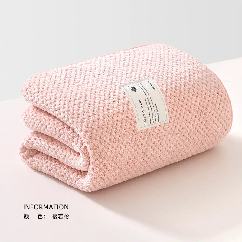 Une couverture Lange Couverture Bébé 105X105cm douce et rose de BABY PREMA, parfaite pour un bébé prématuré, soigneusement pliée sur un fond minimaliste, transmettant une sensation de chaleur et de confort.