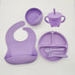 Ensemble d'alimentation pour bébé en silicone violet comprenant un bavoir, un bol, un gobelet avec poignées, une assiette divisée, une cuillère et une fourchette en silicone de haute qualité ; le tout disposé sur fond blanc est désormais connu sous le nom d'Ensemble 6-8 Pièces de Vaisselle pour enfants de BABY PREMA.