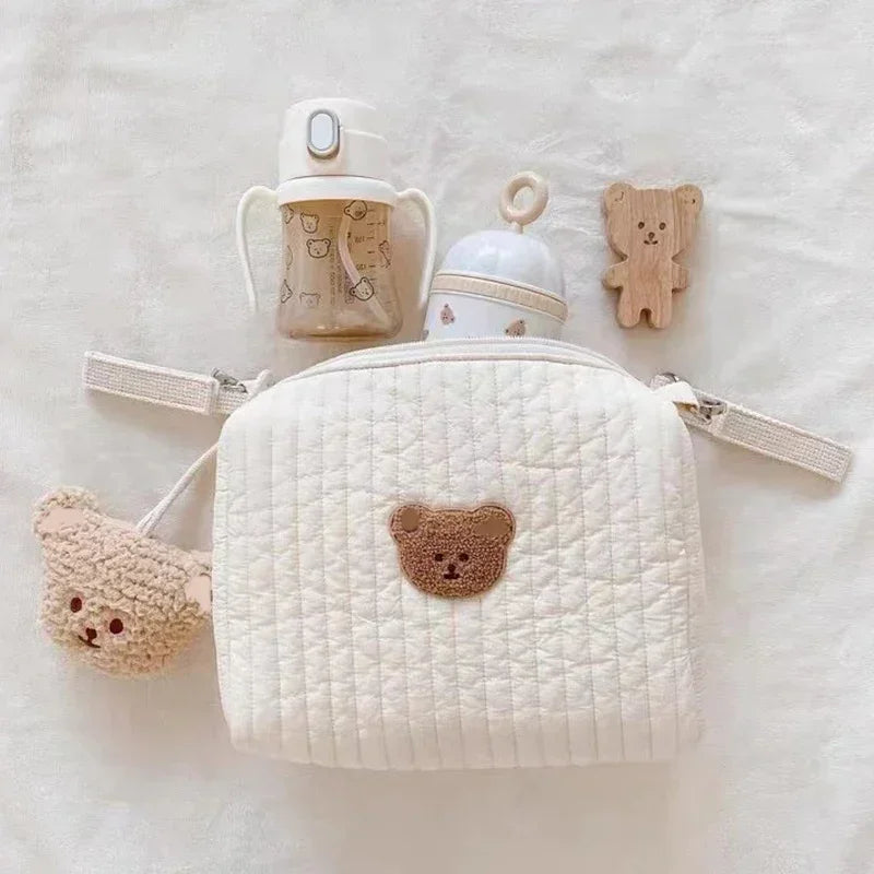 Une collection de Sac à Couches en Coton pour poussette adorables avec un thème d'ours, y comprenant un petit sac à dos matelassé léger avec un visage BABY PREMA.