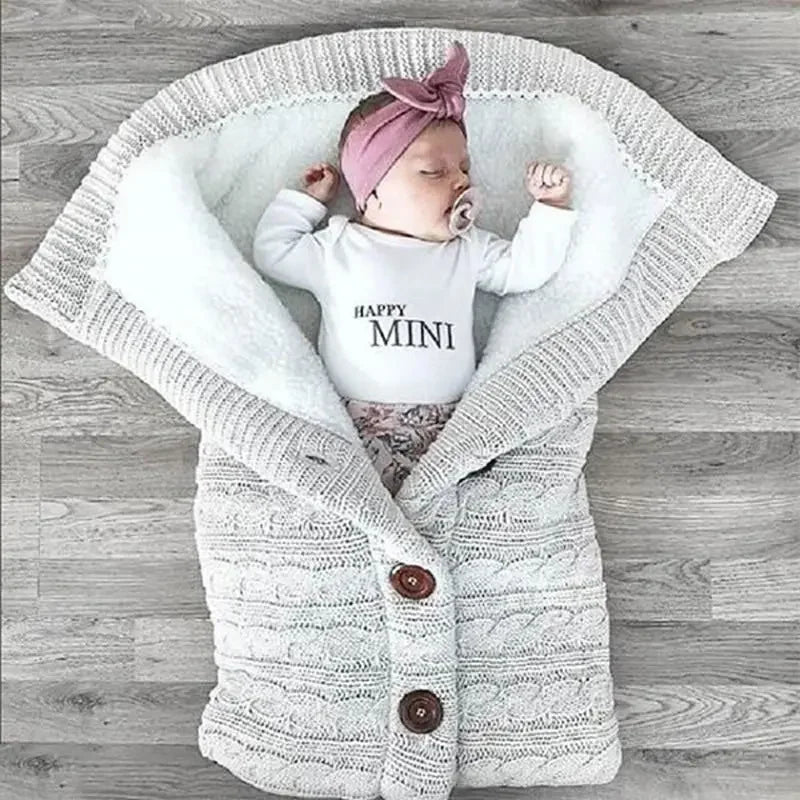 Un bébé paisiblement endormi, confortablement enveloppé dans une Couverture de Poussette Pour Bébé BABY PREMA avec un slogan fantaisiste "happy mini", et enfilant un joli bandeau à nœud rose après avoir profité d'un bain apaisant.