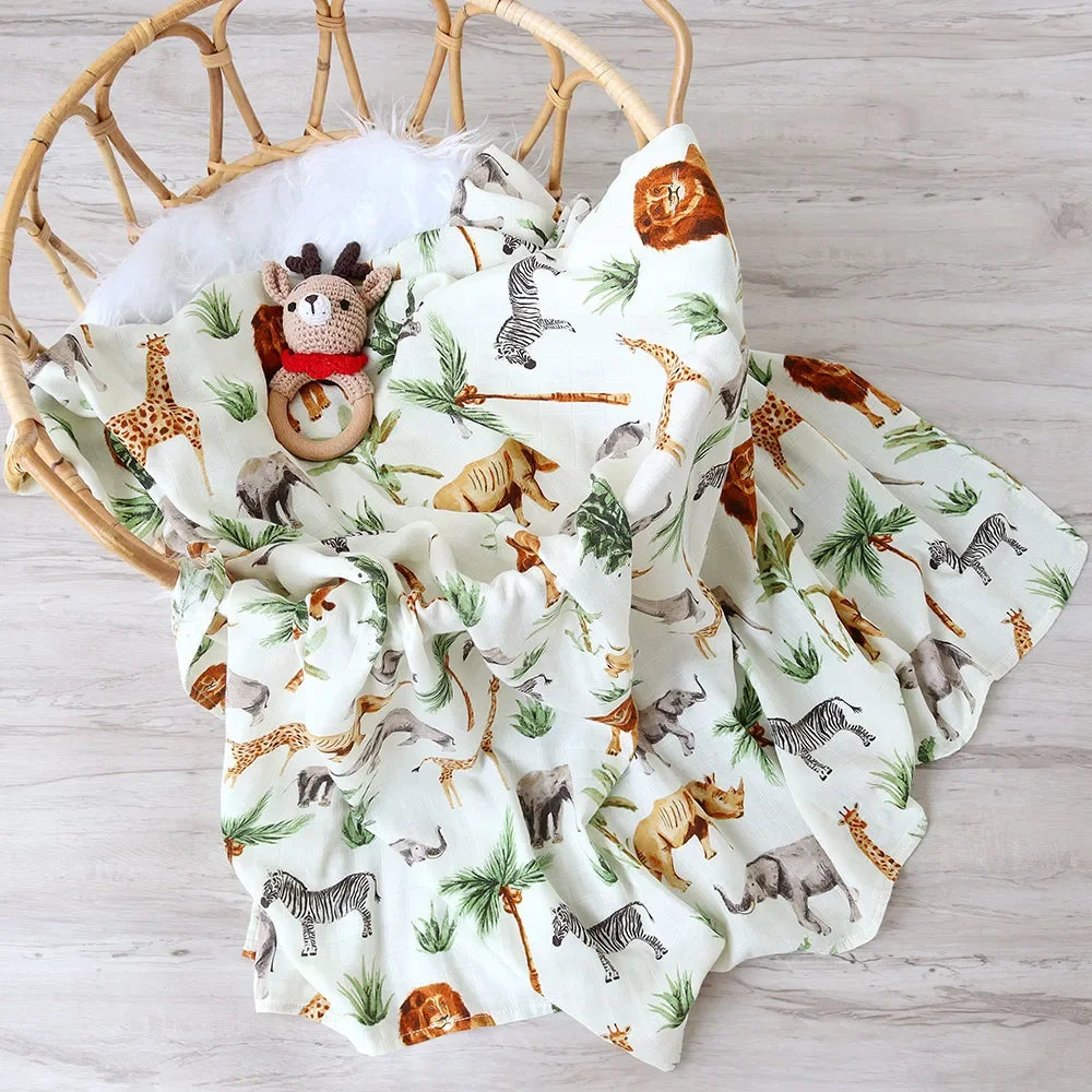 Un accessoire bébé confortable : une Couvertures en Bambou Bébé | Emmaillotage moelleuse avec un imprimé d'animaux de safari niché dans un panier tressé, accompagné d'une m de la marque BABY PREMA.