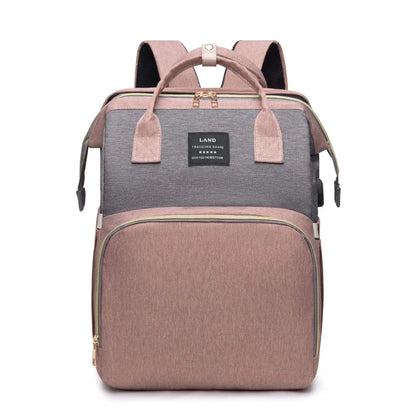 Un SAC stylé A LANGER CONNECTE 3 EN 1 | Sac à dos POUR MAMAN & BEBE conçu avec un mélange de tissus gris et marron, comportant de multiples compartiments et une étiquette griffée "mon bébé" sur le devant par BABY-PREMA.