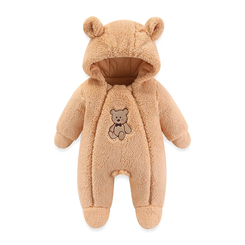 Une combinaison pour bébé en peluche de couleur beige avec une capuche attachée ornée d'oreilles d'ours et un petit ours en peluche brodé sur la poitrine. Cette Barboteuse à Capuche BABY-PREMA est affichée.
