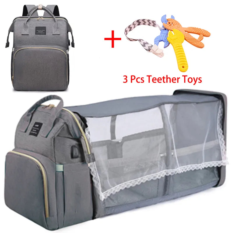 Sac à langer multifonctionnel BABY PREMA pour enfant qui se transforme en berceau de voyage léger avec un ensemble bonus de trois jouets de dentition.