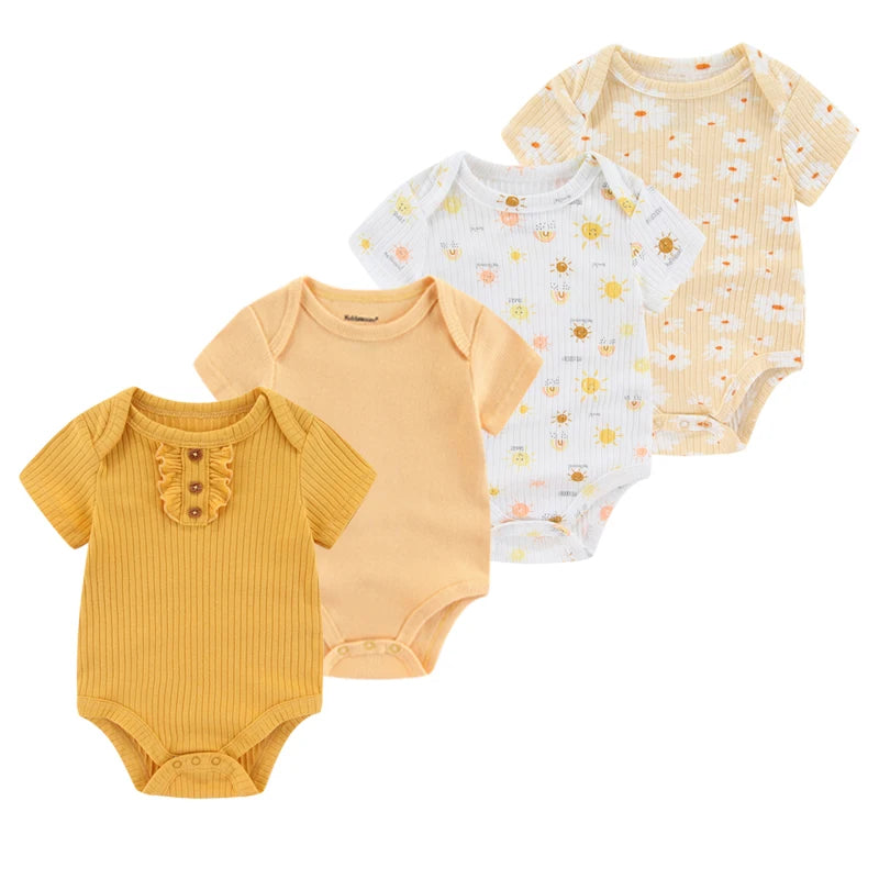 Quatre grenouillères pour bébé, en coton doux, sont disposées en rangée soignée. Le Lot de 4 Bodies Coton Bébé Couleurs été de BABY PREMA est jaune avec des volants, pêche, blanc avec des motifs soleil et beige clair avec des motifs soleil et nuages. Tous ont des manches courtes et des fermetures à boutons-pression.