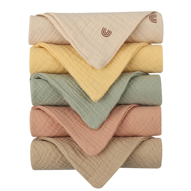 Une sélection soigneusement empilée de couvertures pliées, BABY PREMA Lot de 5 Langes Bébé en Coton, dans une variété de couleurs chaudes, conçues pour un confort prématuré.