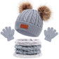 Ensemble chauffe-hiver BABY PREMA : bonnet tricoté gris confortable avec pompons moelleux, écharpe assortie et gants prêts pour l'enfant par temps froid.