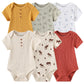 Une collection de six combinaisons à manches courtes pour bébé de différentes couleurs et motifs, dont jaune moutarde, vert avec vélos, blanc avec voiliers, beige avec boutons marron, beige avec élan et rouge rouille. Ces confortables Lot 6 Body Coton Bébé Manches Courtes de BABY PREMA sont parfaites pour votre bébé.