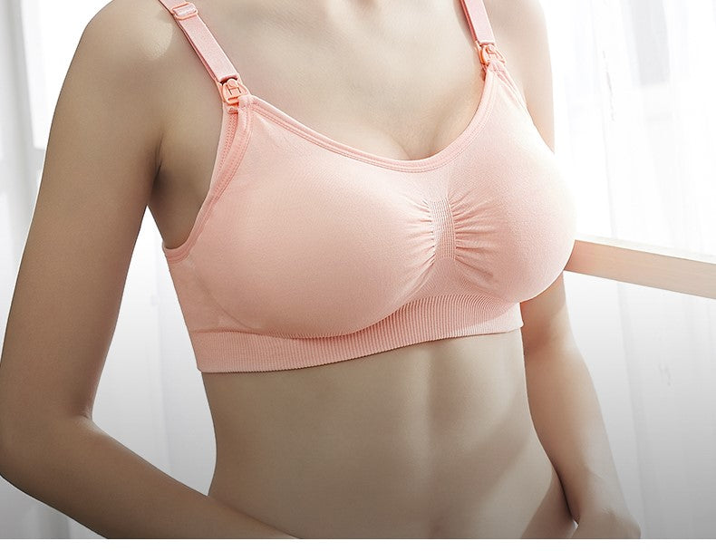 Vue rapprochée d'une petite femme portant un soutien-gorge de sport BABY PREMA couleur pêche (Soutien Allaitement doux Uni), en se concentrant sur le haut du corps sans montrer le visage.