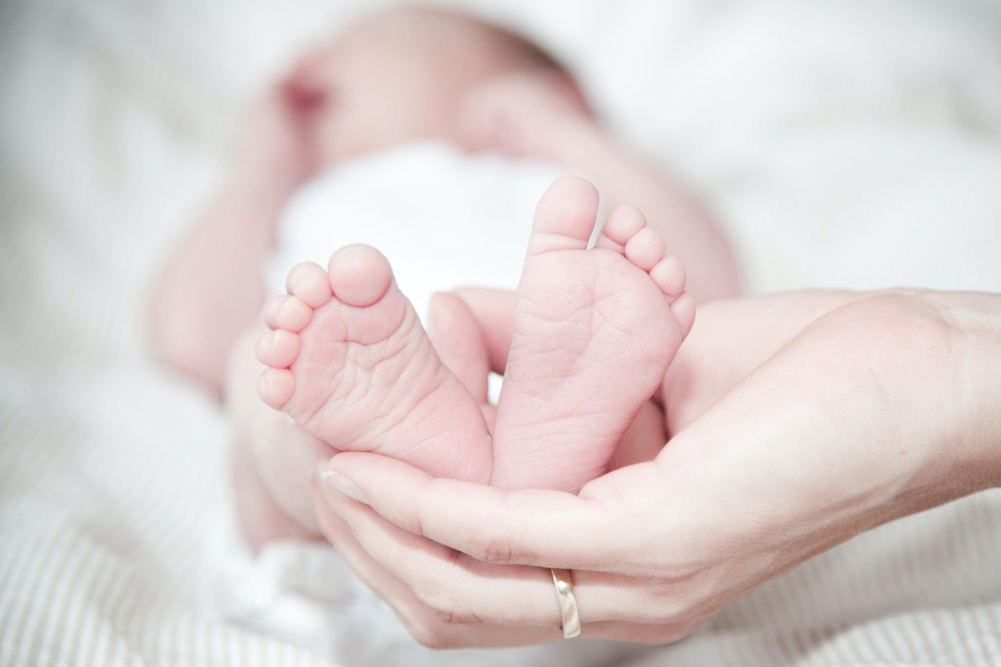 Petite Carte Cadeaux Naissance bercée doucement dans les mains d'un parent, symbolisant l'attention et la tendresse avec les accessoires indispensables BABY-PREMA.